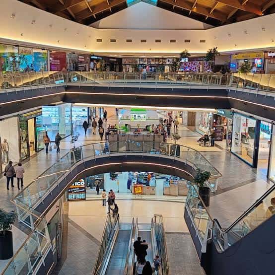 Interior del centro comercial mostrando las escaleras mecánicas y los diferentes niveles de tiendas
