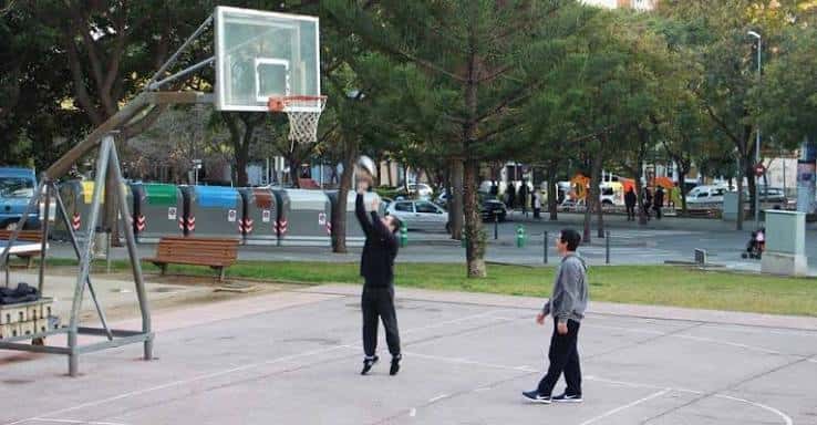 Jugadores practicando baloncesto en la pista al aire libre