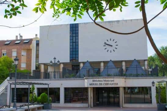 Vista exterior de la Biblioteca Miguel de Cervantes con su fachada blanca y reloj