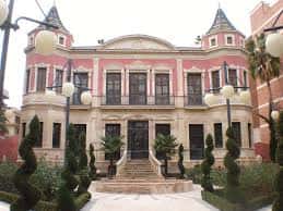Vista exterior del edificio de la Casa del Deporte con escalinata y jardines