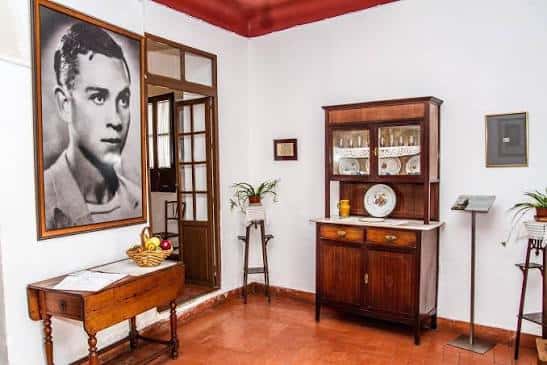 Interior de la Casa Museo Miguel Hernández con retrato del poeta y mobiliario tradicional