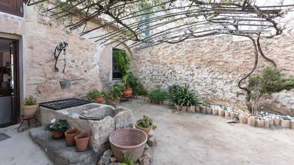 Patio interior de la Casa Museo Miguel Hernández con fuente y vegetación mediterránea