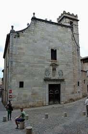 Fachada frontal de la Iglesia de Sant Lluc con personas en primer plano