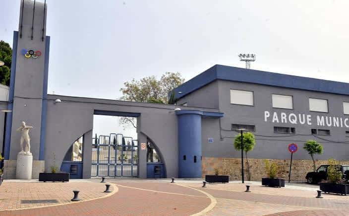 Entrada principal del Parque Municipal de Deportes San José con fachada moderna y escultura