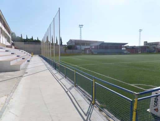 Campo de fútbol del parque con gradas y vallas perimetrales bajo cielo despejado