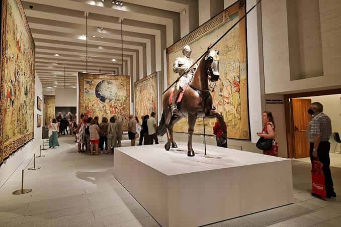 Sala principal con tapices históricos y estatua ecuestre en exhibición