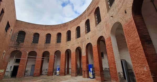 Vista del patio circular interior de La Presó con arcos de ladrillo y cielo despejado