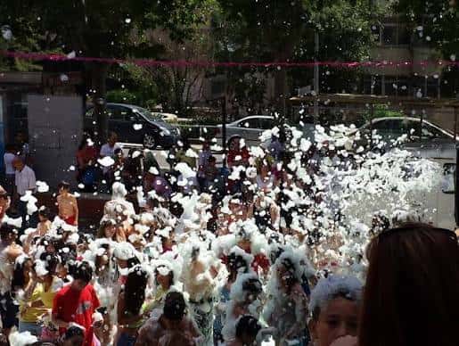 Revetlla de Sant Joan con espuma y gente celebrando en la plaza