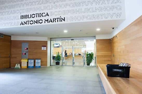 Entrada principal de la Biblioteca Antonio Martín con señalización clara y ambiente acogedor