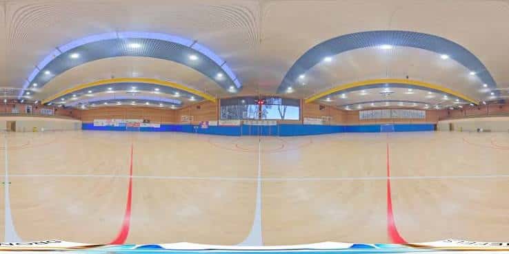 Vista panorámica del interior del polideportivo Can Roca con pista de baloncesto y gradas