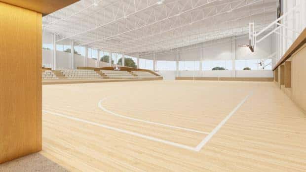 Render arquitectónico de la pista de baloncesto con gradas y iluminación natural