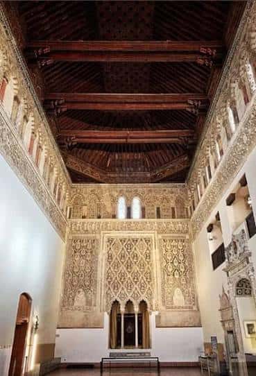 Interior de la sala principal del Museo Sefardí con muros decorados y techumbre de madera