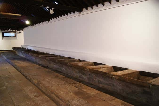 Vista panorámica del interior de la sala de arte mostrando los lavaderos históricos y las paredes blancas