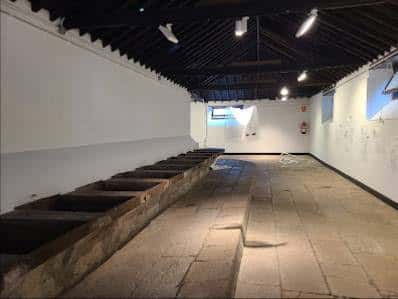 Interior amplio de la sala de arte con iluminación moderna y estructura de lavaderos de piedra