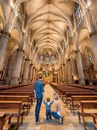Interior de la nave central de la Basílica con bóvedas de crucería y vitrales