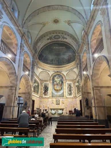 Interior de la iglesia con bóvedas, altar y fieles sentados