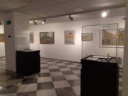 Interior de la Sala Princesa Zaida con exposición de arte y suelo de baldosas en damero