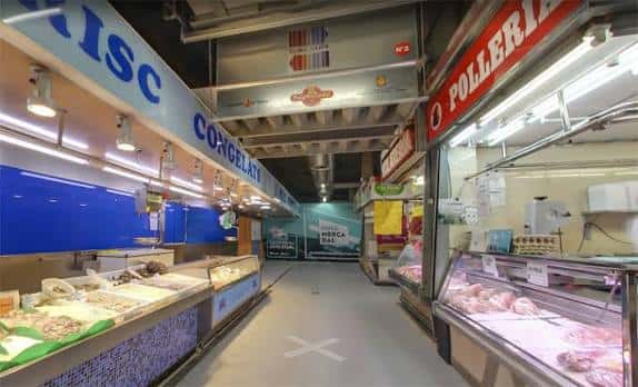 Interior del mercado con pasillos comerciales y puestos de carnicería y pescadería