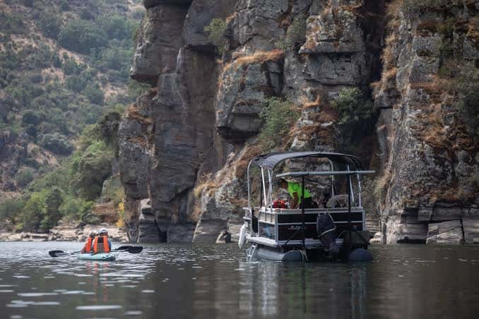 Barco turístico navegando por el río Duero con cañones rocosos al fondo