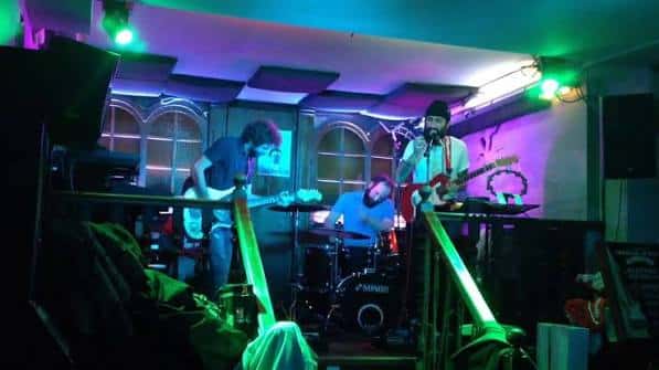 Concierto en vivo en el Avalon Café Zamora con banda en escenario bajo luces de colores