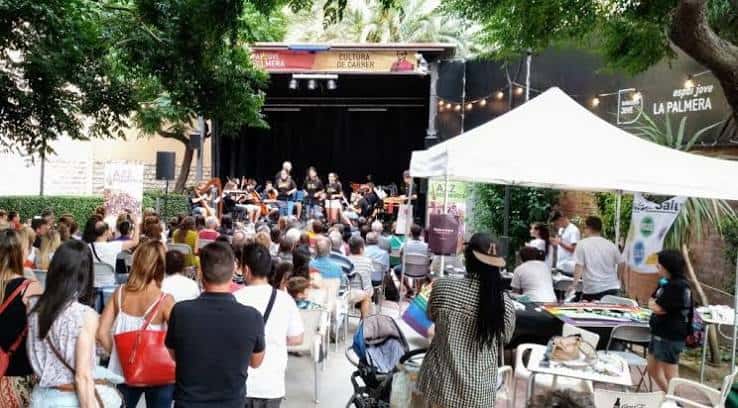 Concierto al aire libre en el escenario de Espai Jove La Palmera con público asistiendo
