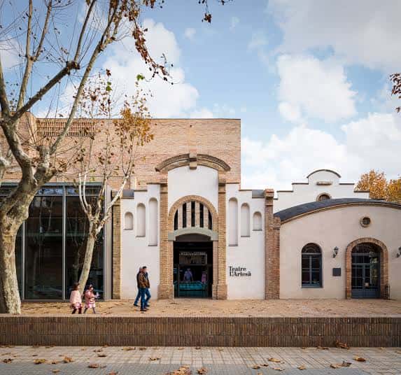 Fachada exterior del Teatro L'Artesà con arquitectura moderna y detalles de ladrillo