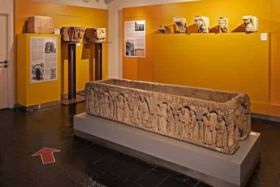 Sala de exposición con sarcófago romano y piezas arqueológicas