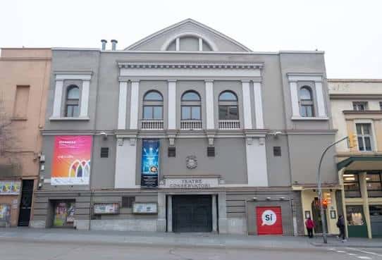 Vista frontal de la fachada del Teatre Conservatori de Manresa con carteles de eventos