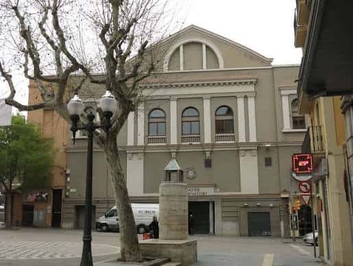 Fachada del teatro desde la plaza, con árbol y farola en primer plano