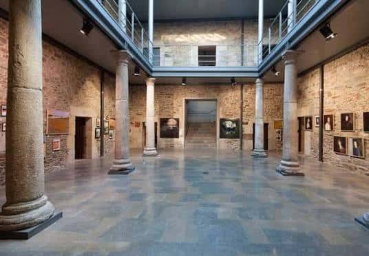 Salón principal del museo con columnas romanas y galería superior