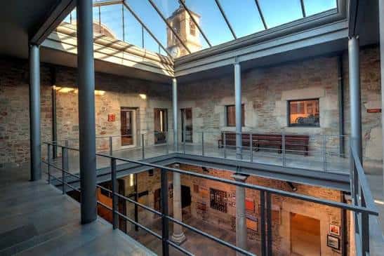Patio interior con estructura de cristal y escalera metálica moderna