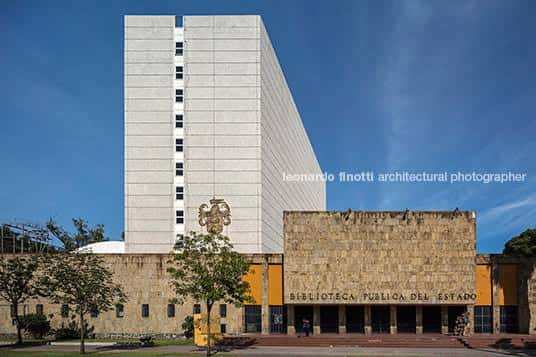 Vista exterior moderna de la Biblioteca Pública del Estado de Guadalajara, mostrando la torre blanca y el edificio de piedra con el nombre visible