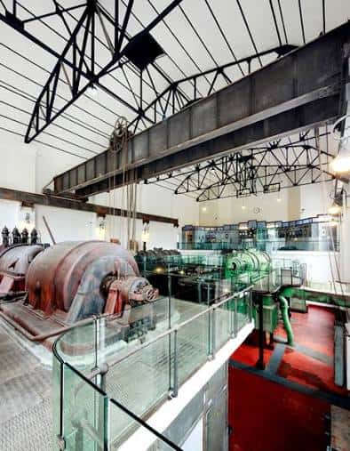 Interior del museo mostrando turbinas históricas y estructura metálica de la nave industrial