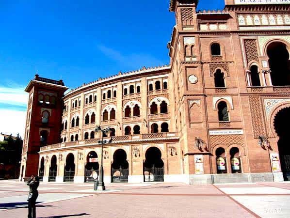 Vista panorámica de la Plaza de Toros de Toledo bajo cielo azul, mostrando su arquitectura neomudéjar con arcos y torres decorativas