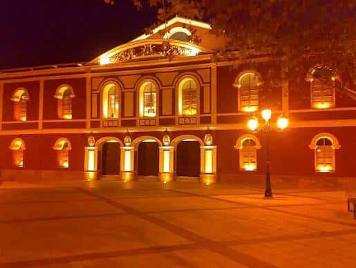 Fachada del Teatro Guerra iluminada por la noche en la plaza