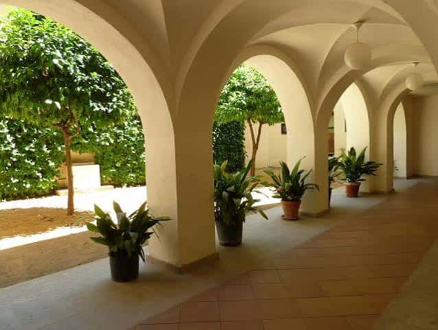 Patio interior del Palacio de la Isla con arcos y plantas decorativas