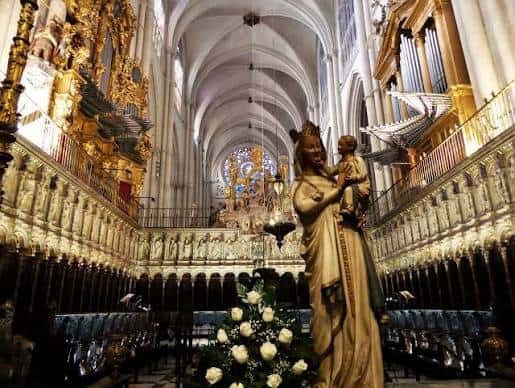 Detalle interior de la catedral con estatua dorada y órgano en el fondo