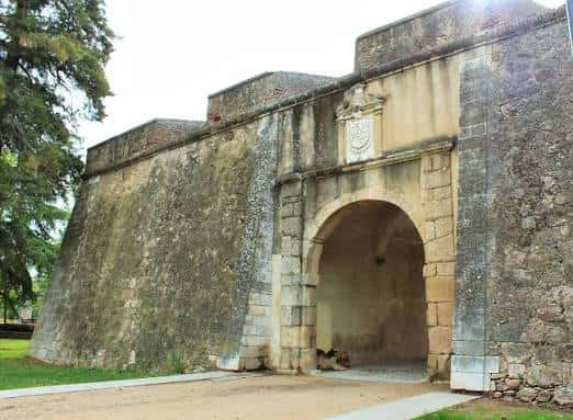 Vista exterior de la Puerta de la Trinidad en Badajoz con su arco de entrada y escudo heráldico