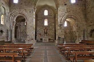 Vista del interior de la iglesia con bancos de madera y altar