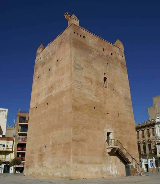 Torre de Torrente desde ángulo lateral, mostrando escalera exterior y fachada bajo cielo azul despejado