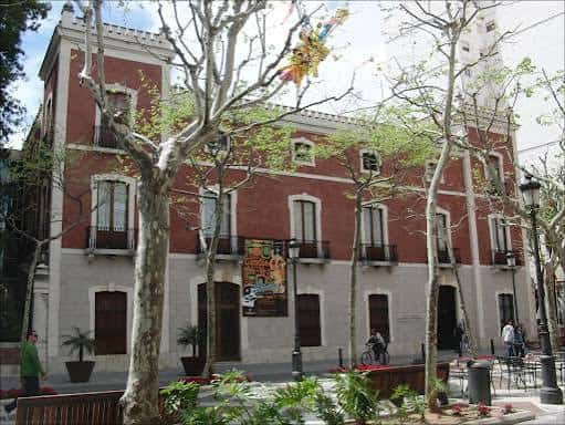 Fachada principal del edificio rodeado de árboles en un día soleado