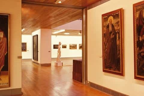 Interior de las salas de exposición con obras de arte y esculturas enmarcadas