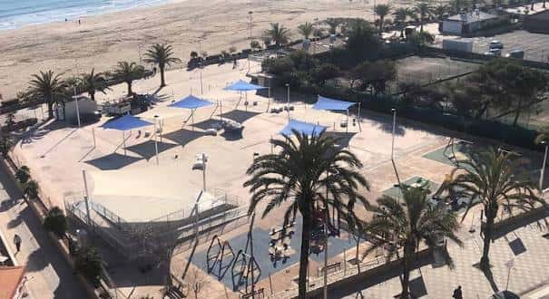 Vista aérea de la plaza con zonas de sombra azules y playa al fondo