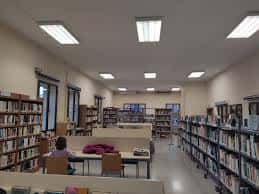 Interior de la sala de lectura con estanterías y mesas de trabajo