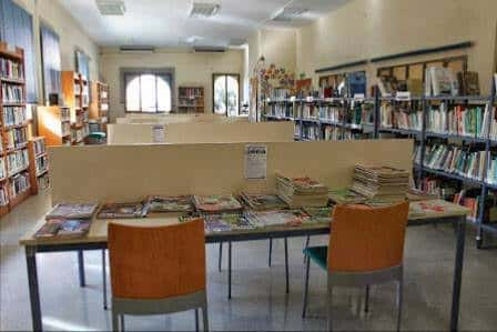 Sala de lectura con mesas de revistas y estanterías
