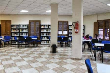 Interior de la sala de lectura con estanterías y mesas de estudio