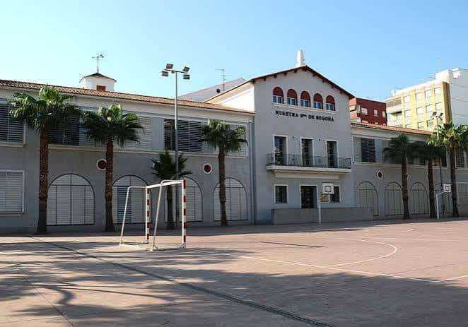 Vista exterior del colegio con patio y canchas deportivas