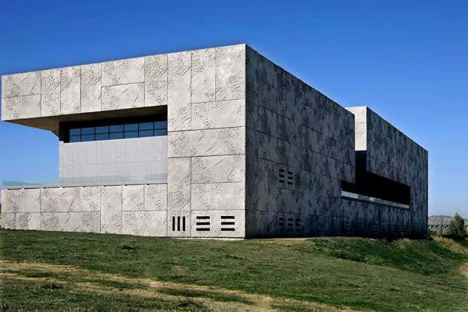 Vista exterior del Palacio de Congresos y Exposiciones de Mérida con fachada de piedra y cielo azul