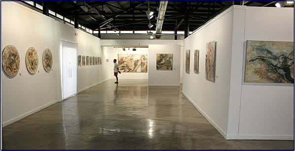 Interior de la sala de exposiciones con obras de arte colgadas y suelo pulido