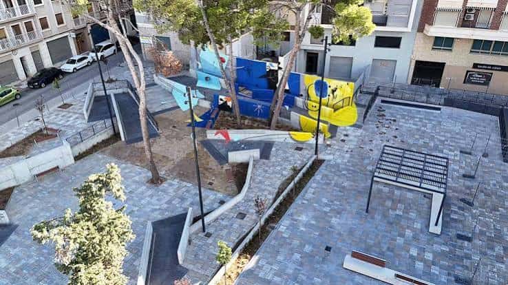 Vista aérea de la Plaza Joan Miró mostrando el área de juegos y la escultura mural